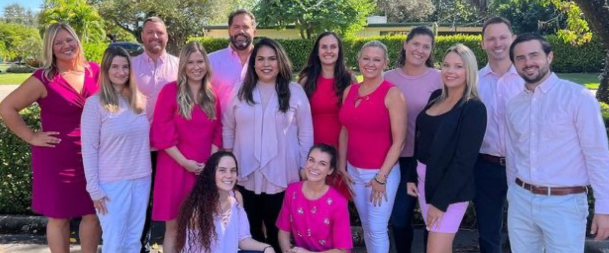 Cottrell Title & Escrow team wearing assorted colors of pink for Breast Cancer Awareness Month